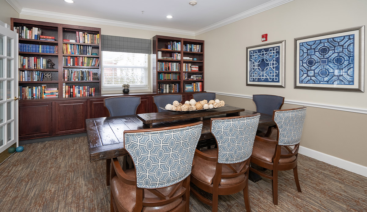 A bright dining room with a stylish table and four matching chairs set for a meal.