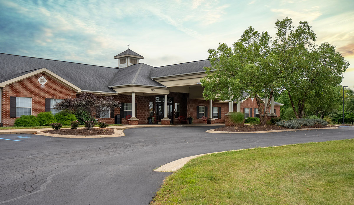 Front entrance of a retirement community building, featuring welcoming doors and landscaped pathways.